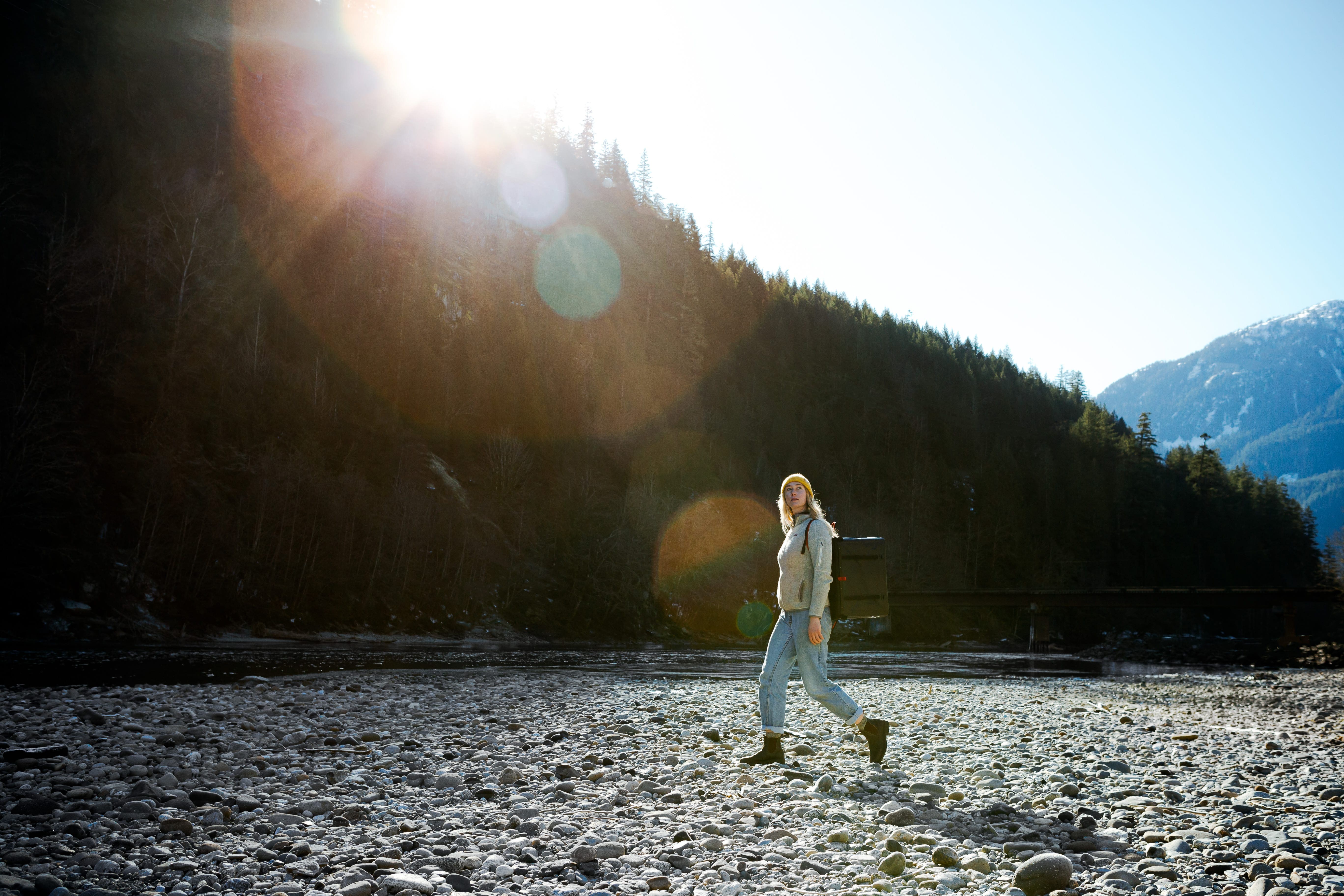 Carrying a RUX 70L to a riverside fire pit while camping